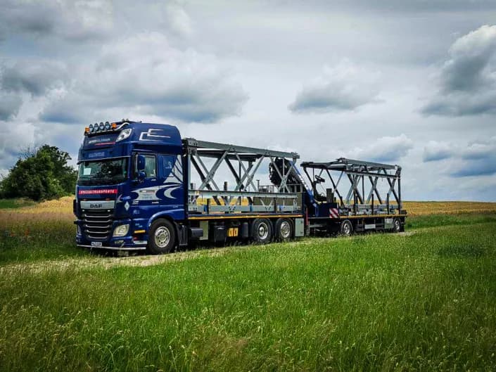 Ladekran-LKW beim Transport von Mastteilen