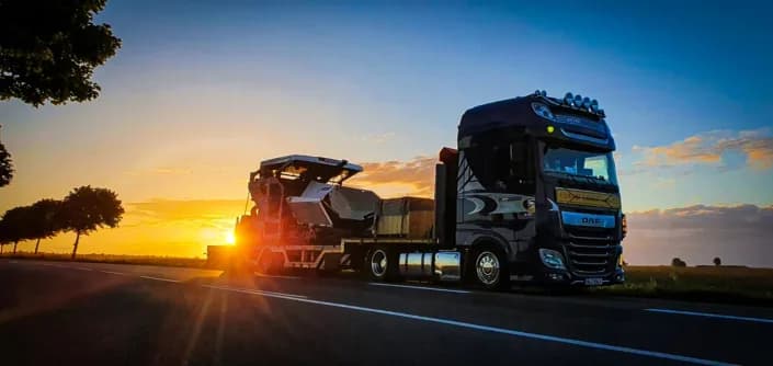 Straßenfertiger auf einem MegaSemi bei Sonnenuntergang